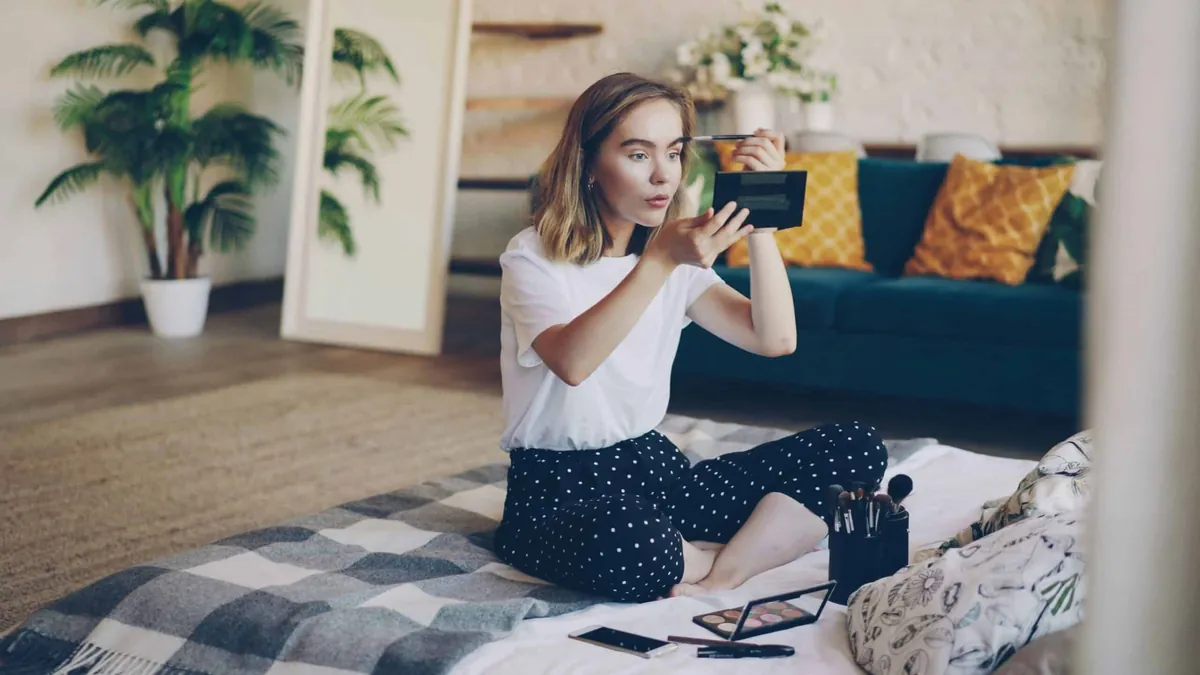 woman doing makeup sitting on the floor