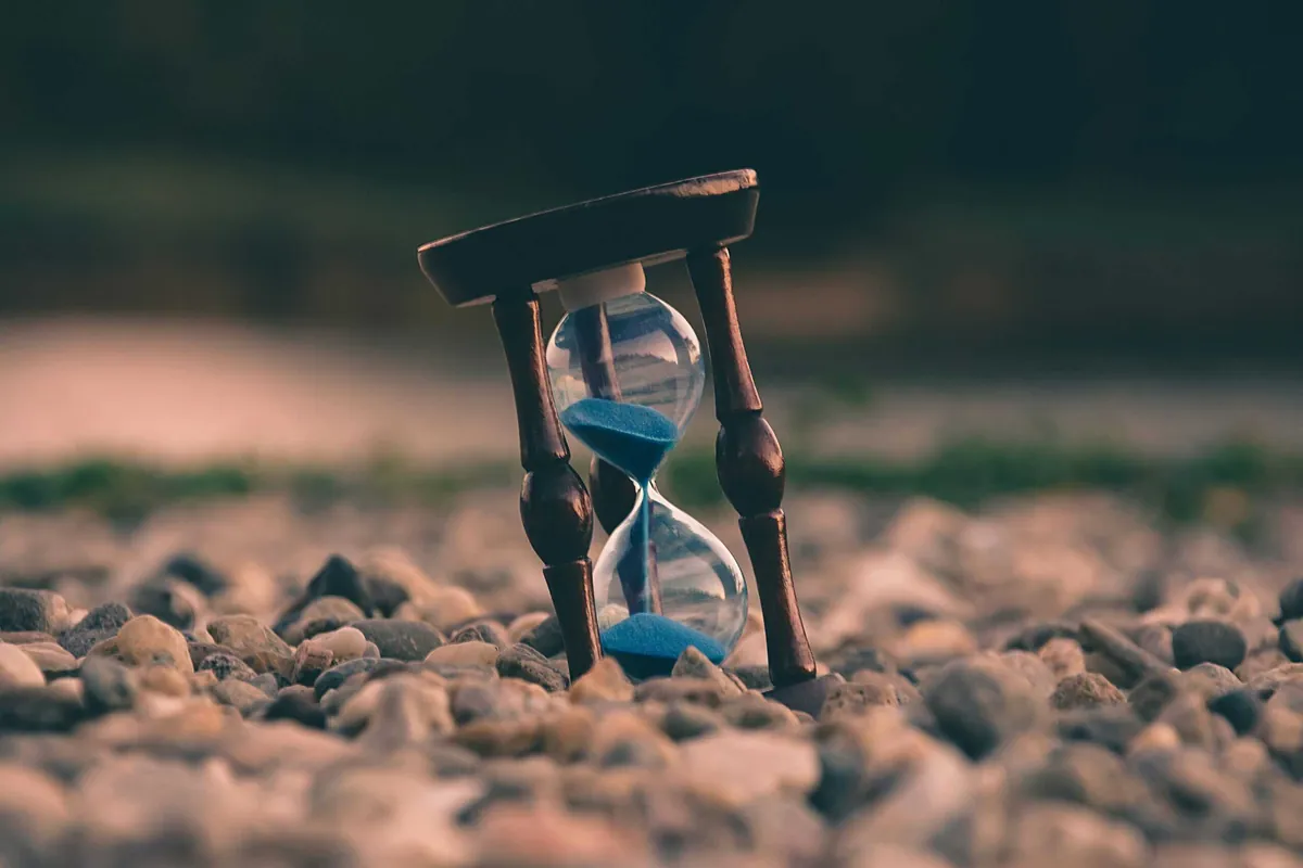 wood framed hourglass stood on rocks