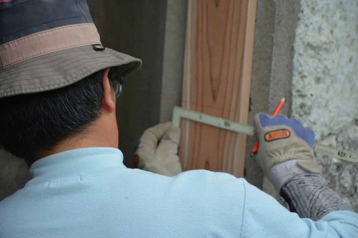 man measuring wood plank