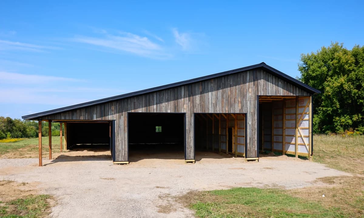 Wood-look machine shed with multiple equipment bays and a covered side area