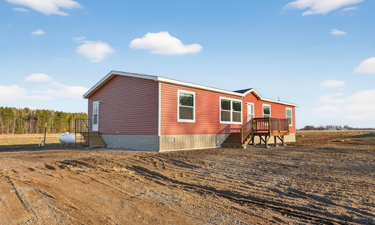 Red single-story modular home with white trim and a wooden front deck