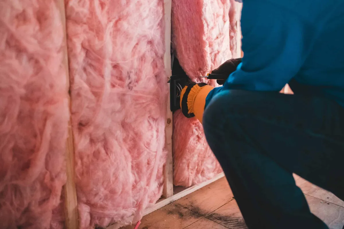 man installing wall insulation