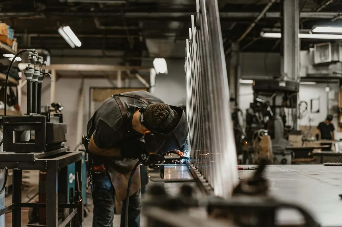 man welding inside factory
